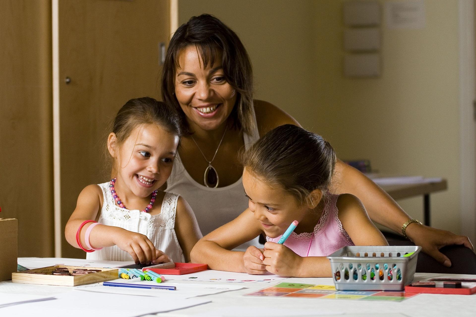 A woman and two children taking part in a craft activity.