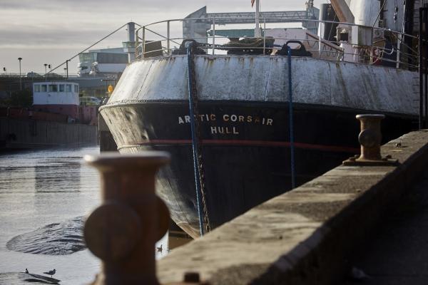 The back of a fishing trawler with Arctic Corsair Hull written on it in large white lettering