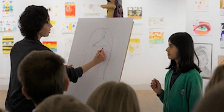Artist Esther Cawley drawing the portrait of a child in a gallery.