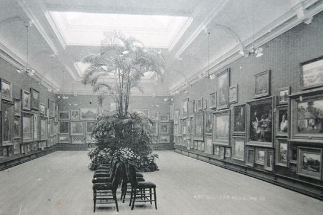 A black and white photograph of a gallery space.