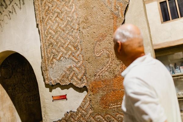 A man looking at a Roman mosaic