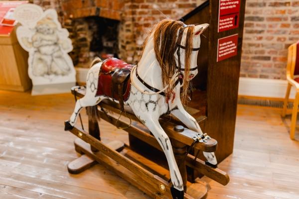 A white and brown rocking horse in a museum