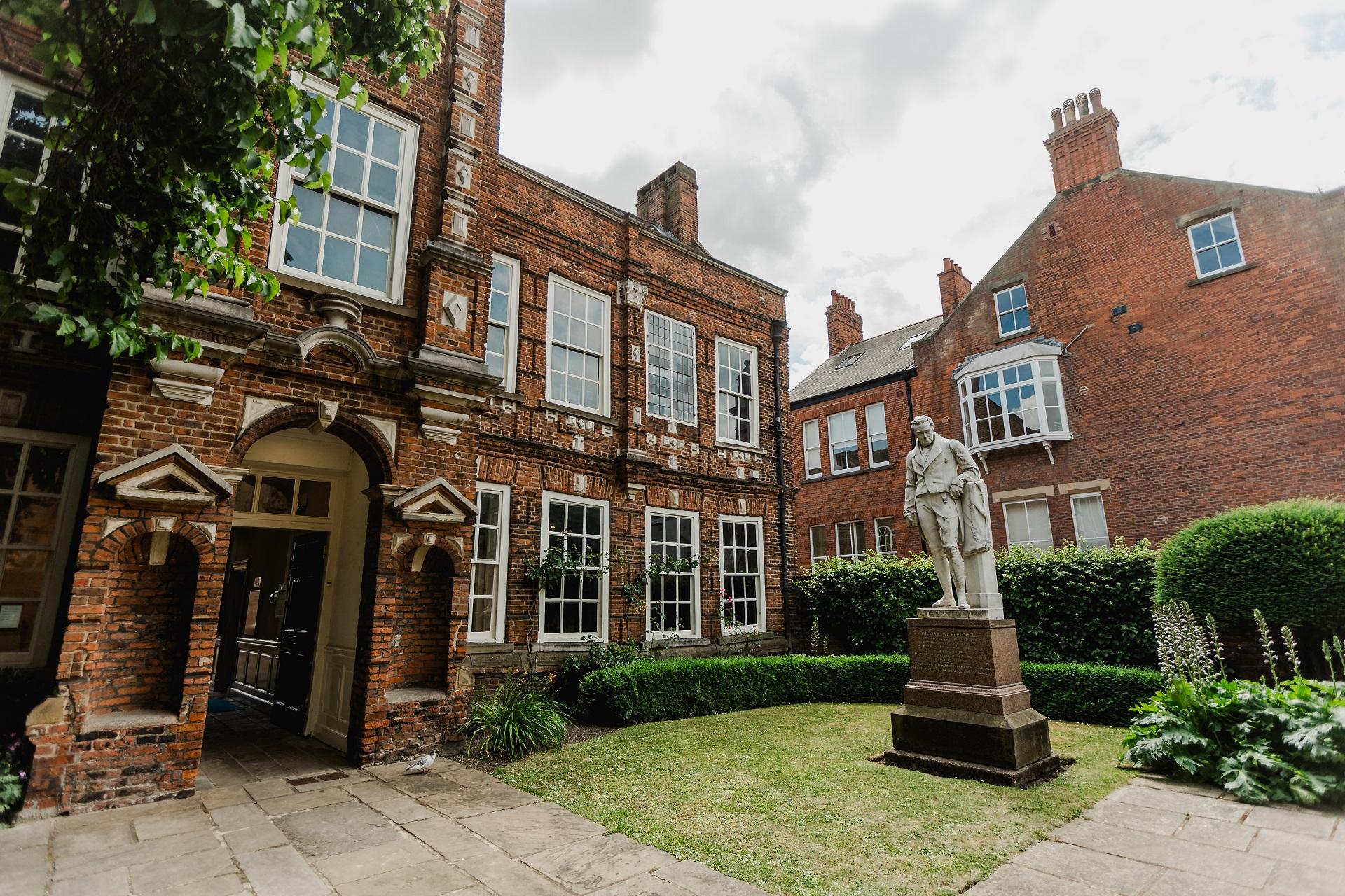 A two storey red brick building with white framed windows