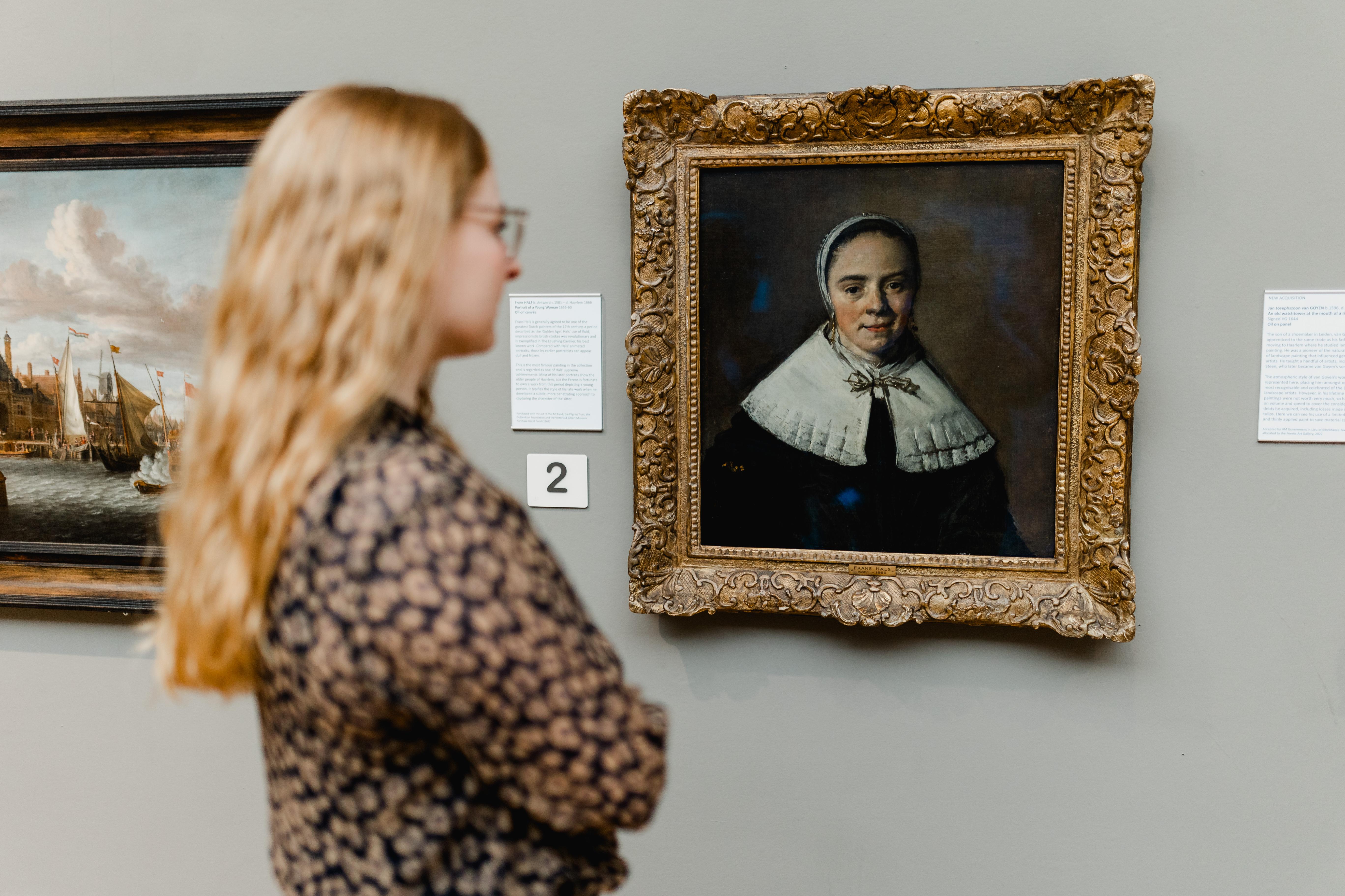 A woman looking at a painting in an art gallery