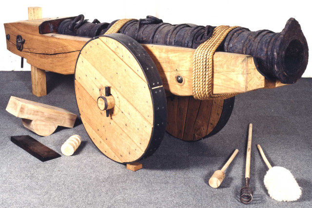 A large metal cannon on a wooden stand and wheels