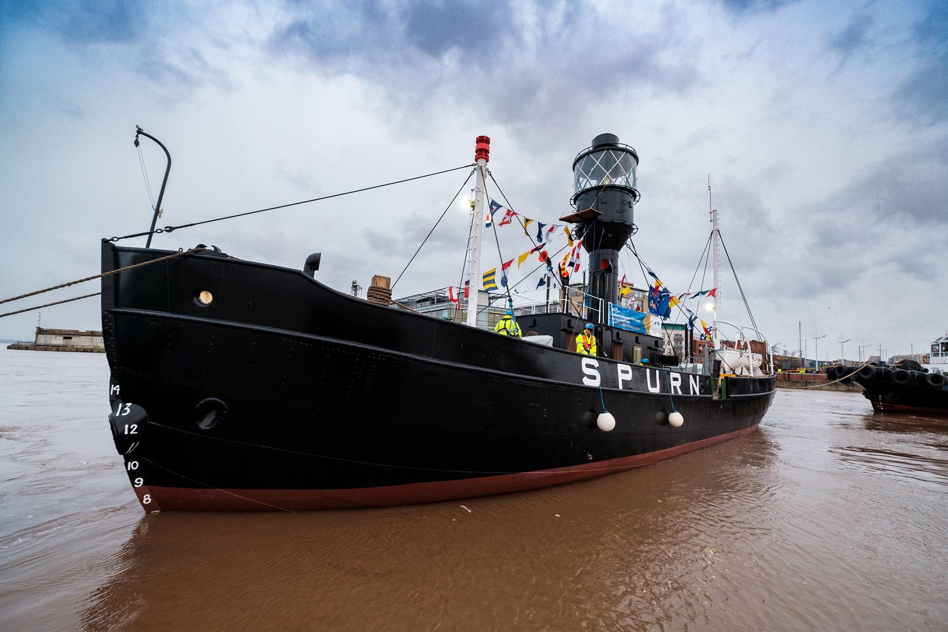 A large black lightship being towed.