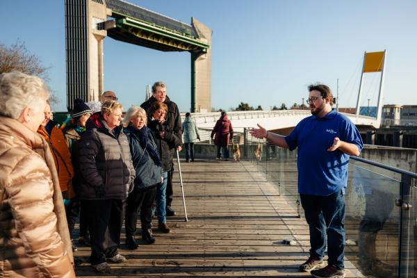 A man talking to a group of people on the river.