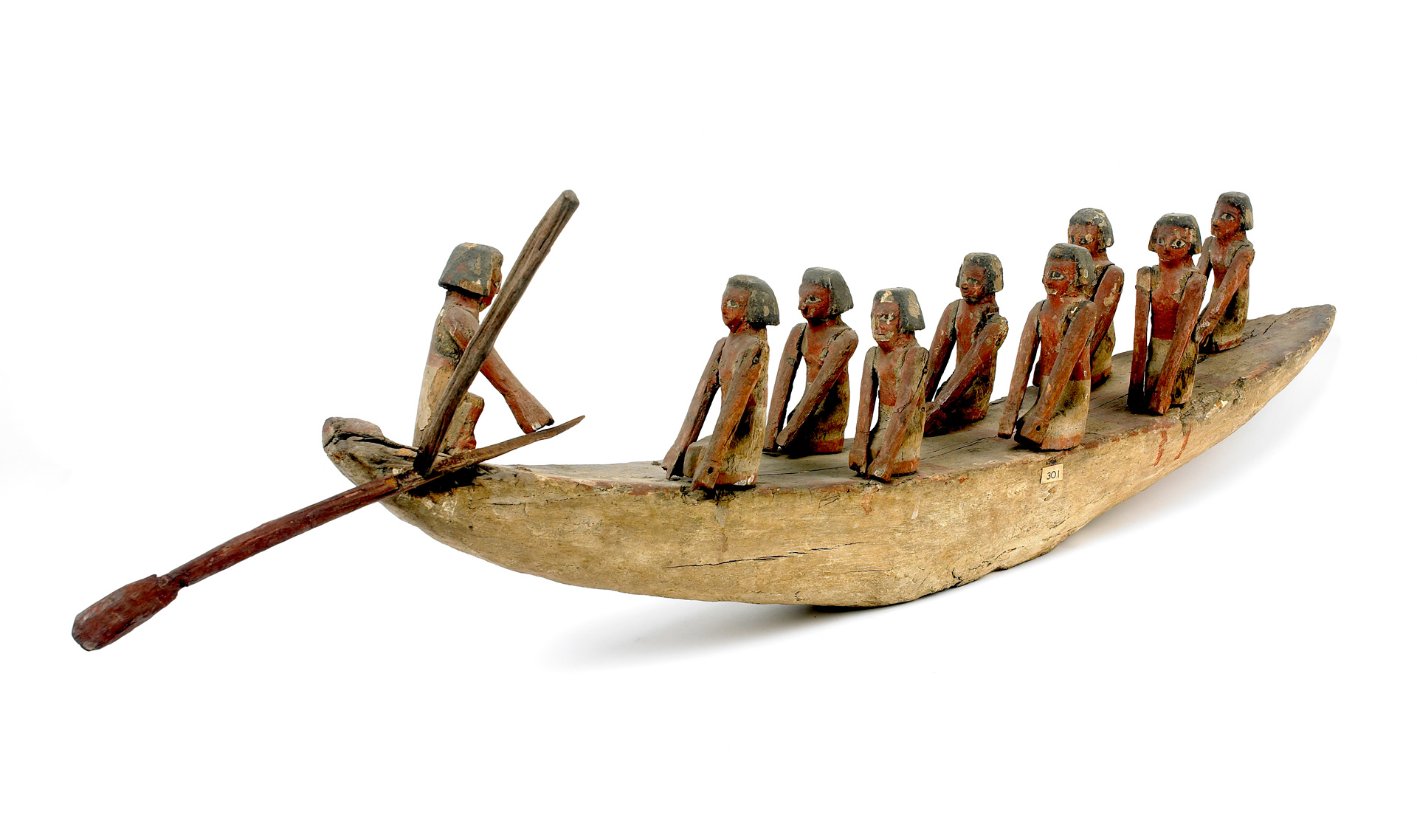 A wooden model of a boat with carved figures on it