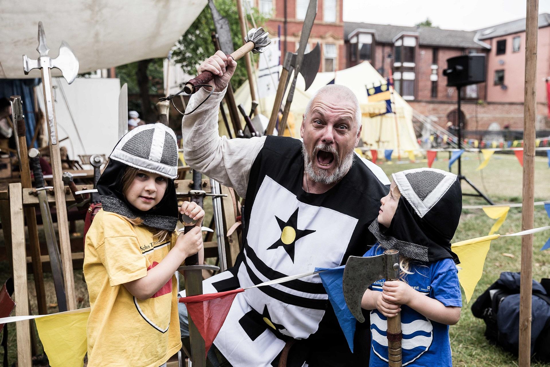 A man and two children dressed in medieval costume.