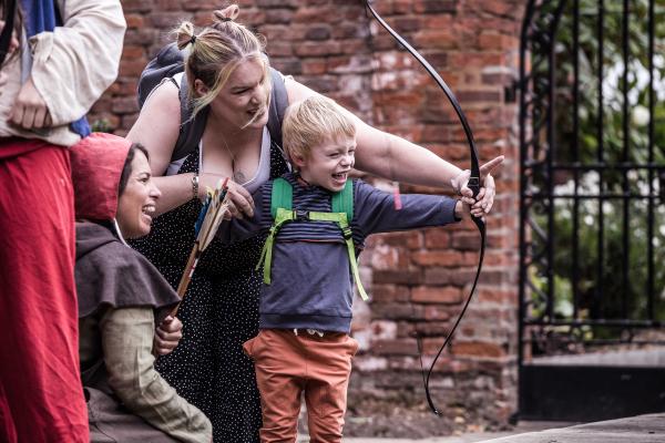 A young boy playing with archery