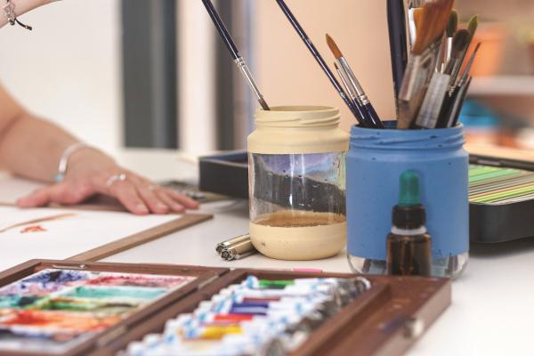 Paints and a pot of paint brushes