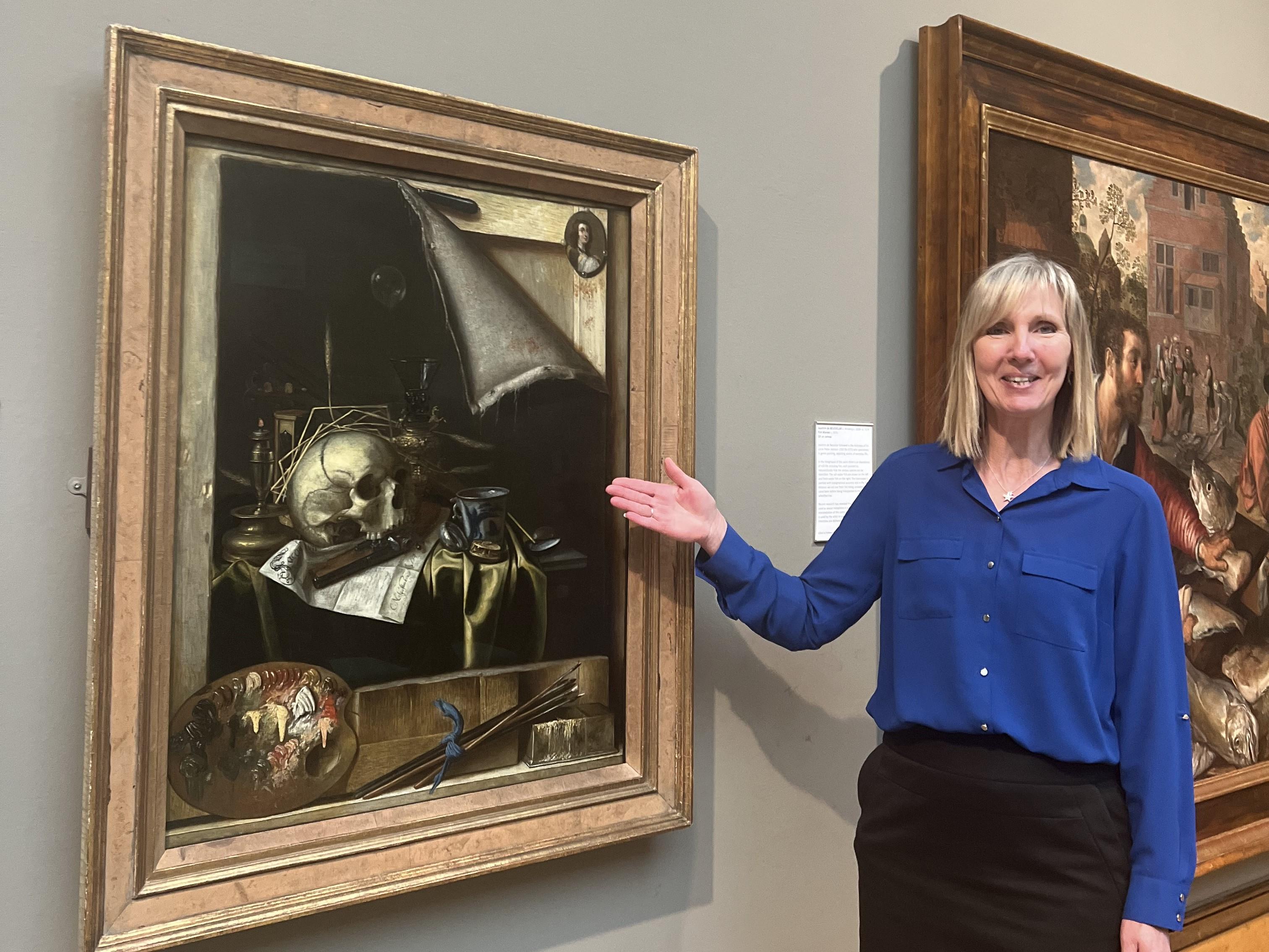 A woman pointing at a painting.