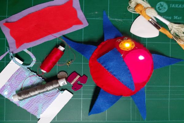 Craft materials including thread and felt. There is a blue and red star made out of felt.