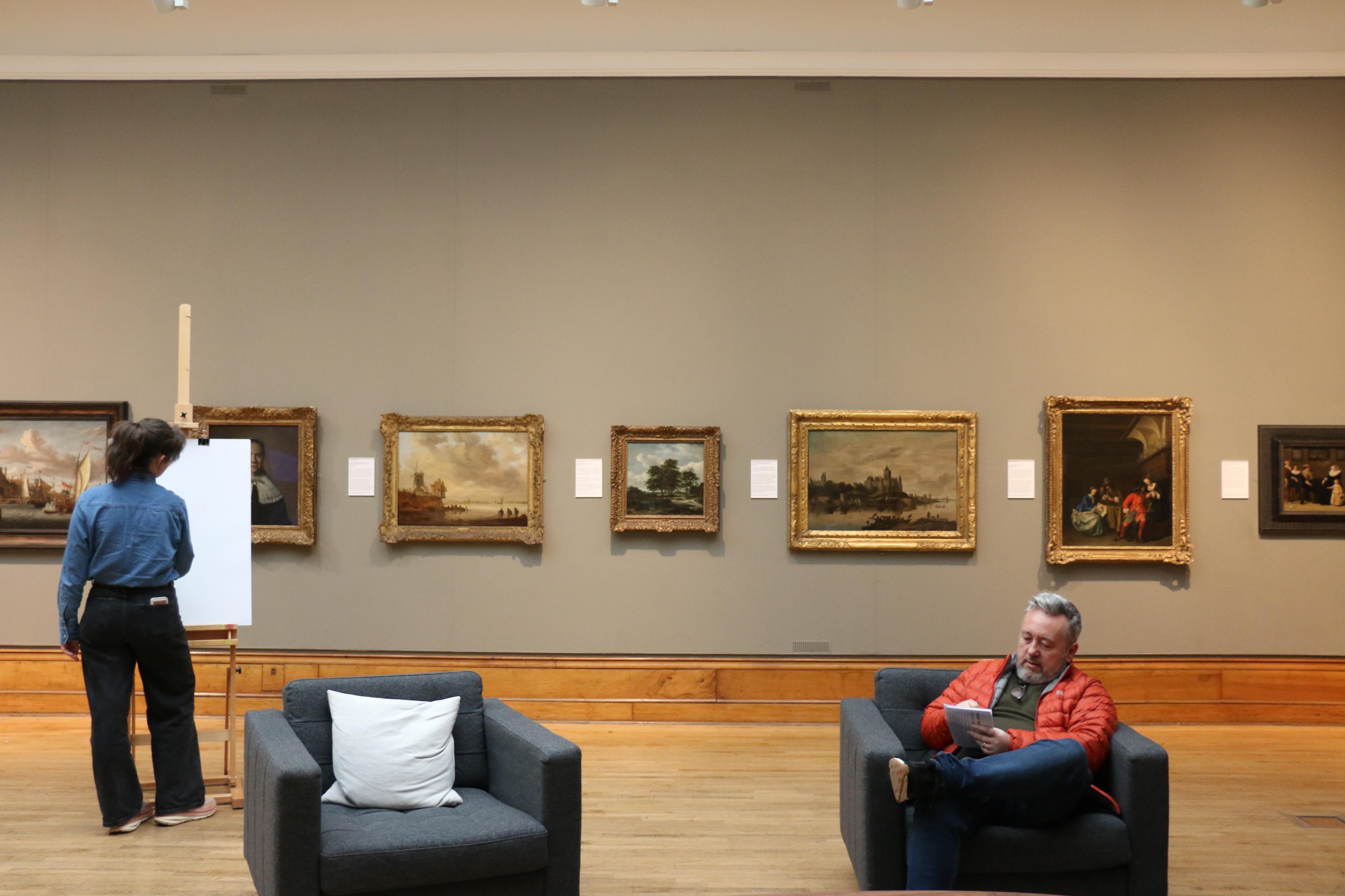 A woman and man drawing in an art gallery