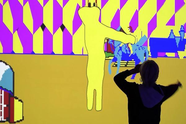 A silhouette of  a person dancing in front of an interactive light display