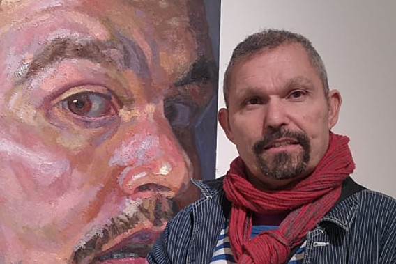 Photo of Nahem Shoa next to his artwork