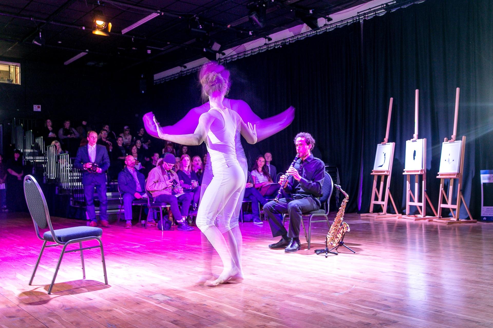 A woman dancing with an audience watching