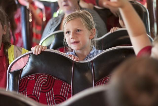 Child sat on the bus in Streetlife Museum taking part in a school led session.