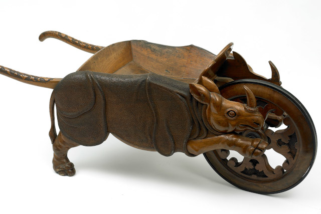 A wooden wheelbarrow made to look like a rhinoceros.