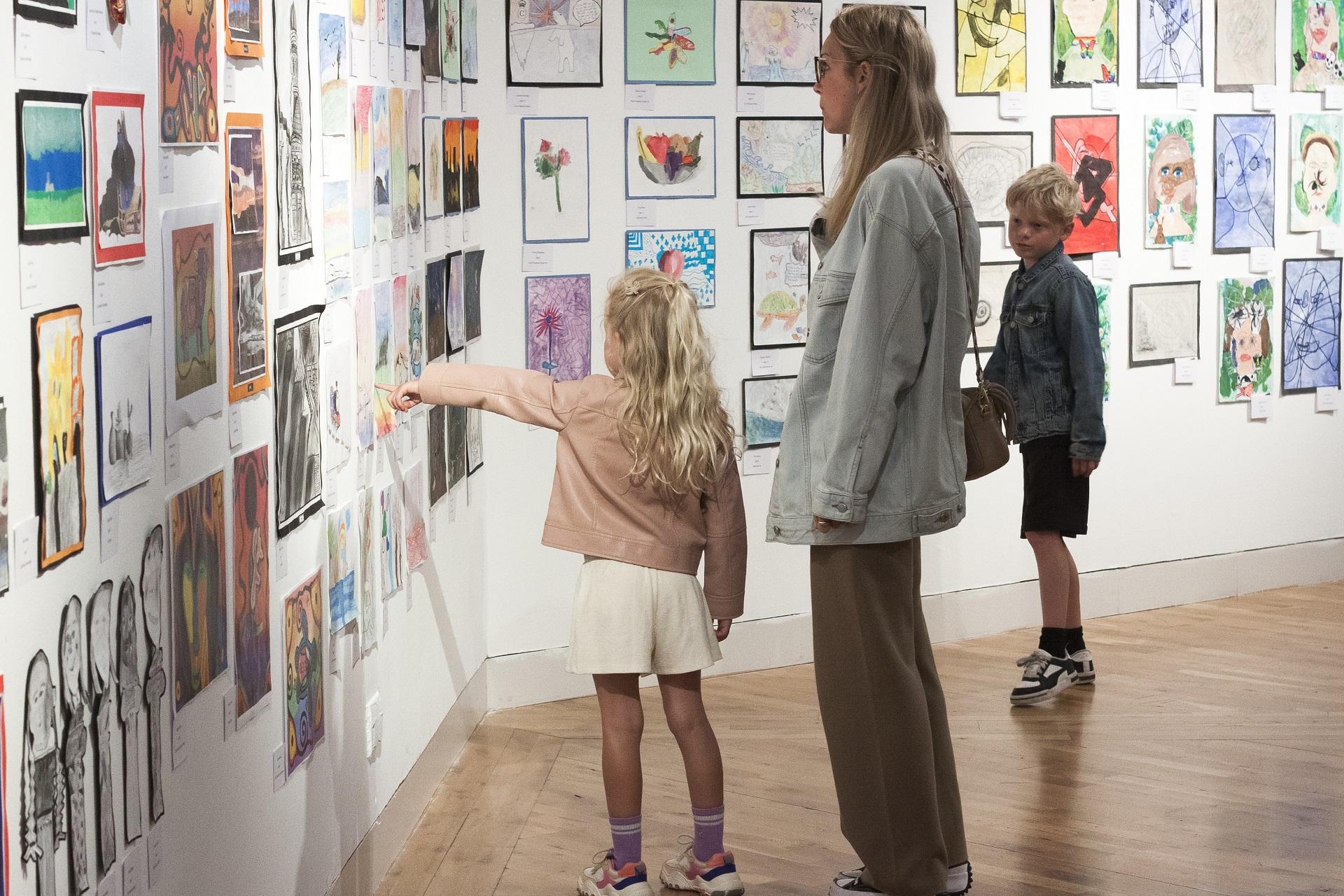 A woman and children looking at art